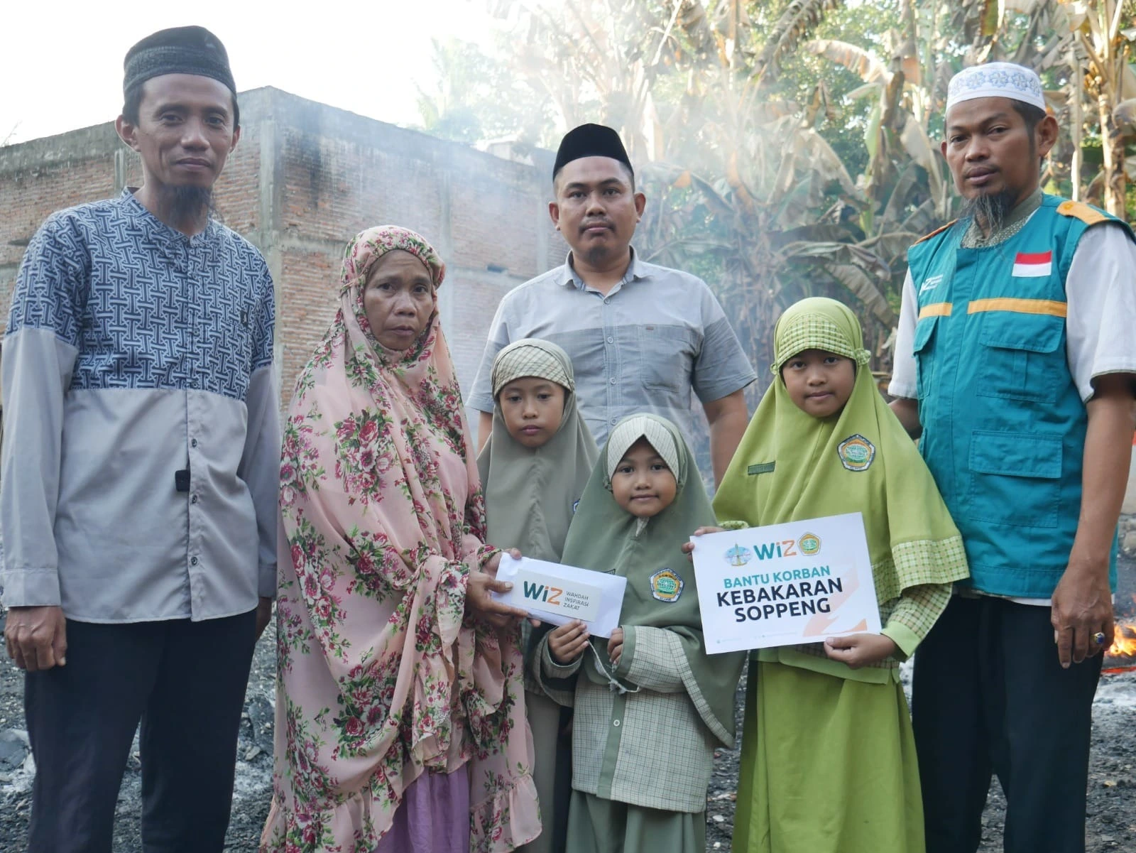 Gambar serah terima bantuan WIZ kepada korban kebakaran.