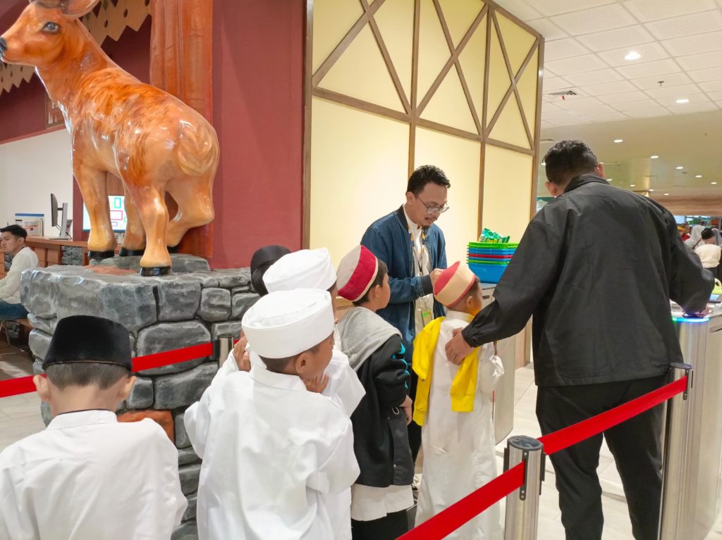 Gambar anak-anak yatim saat bermain di wahana es Trans Snow World dan berbuka puasa.