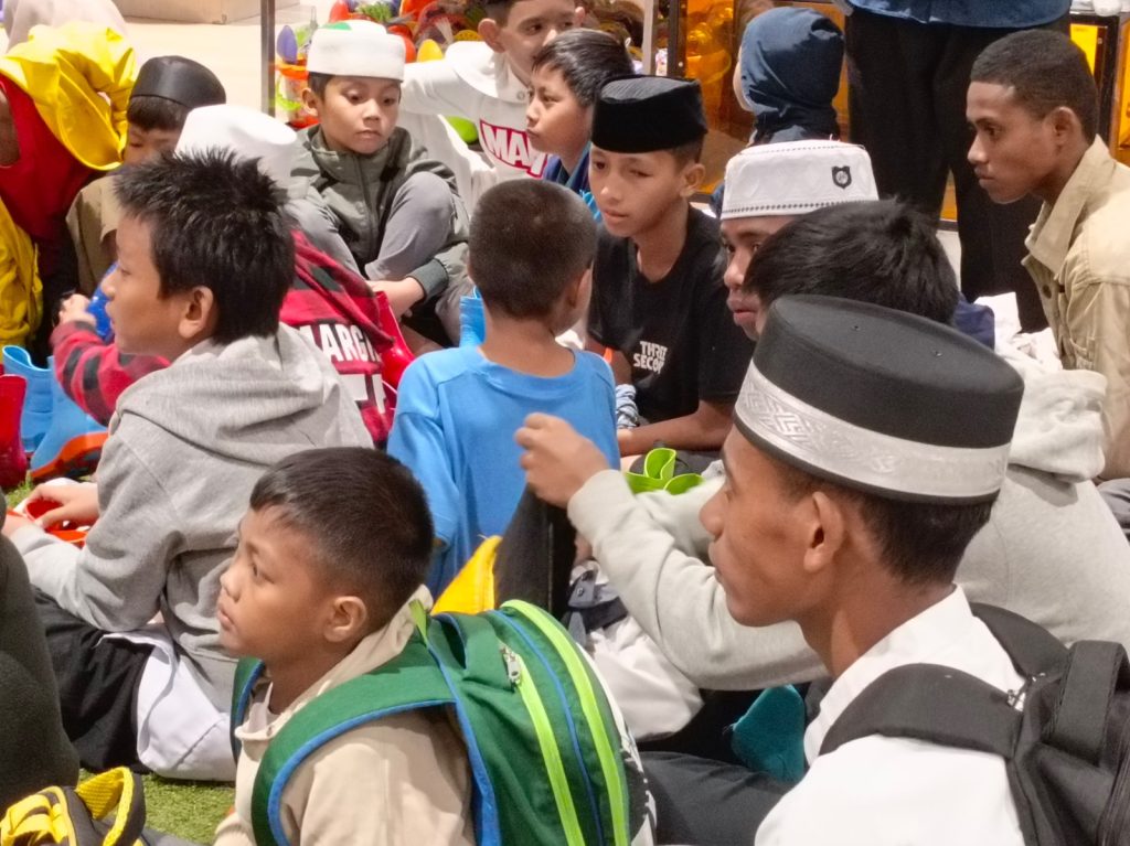 Gambar anak-anak yatim saat bermain di wahana es Trans Snow World dan berbuka puasa.
